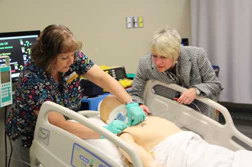 Susan Dunington, RRT and Anesthesia Assistant professor, demonstrates Michener's simulation manikin to Michener President and CEO Maureen Adamson