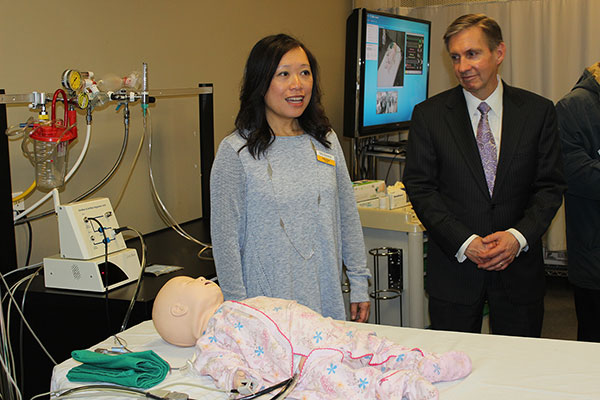 Respiratory therapist Felita Kwan, a member of the faculty at The Michener Institute of Education at UHN, explains to her audience, including Dr. Peter Pisters, UHN President and CEO, the use of the “SimBaby” in the Institute’s Centre for the Advancement of Simulation Education, or CASE. (Photo: UHN)​