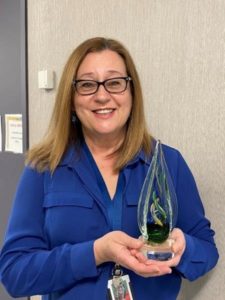 A recipient holding up her 2020 Excellence in Clinical Teaching and Supervision Award from Michener