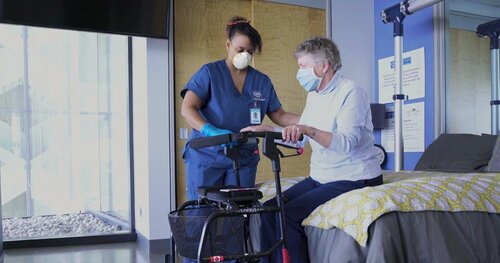 Personal Support Worker helping an elderly patient with a walker