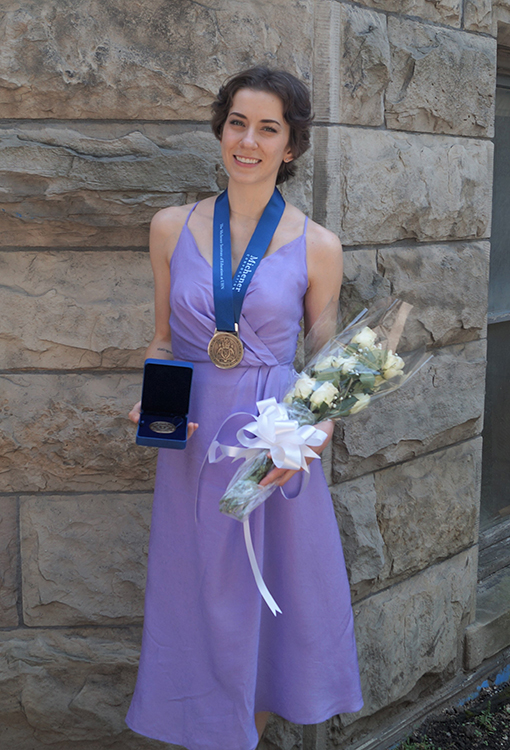Photo of Victoria Marko holding the Governor General's Collegiate Bronze Medal and flowers