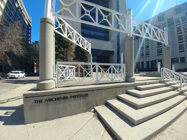 The entrance steps and sign for The Michener Institute, with modern buildings in the background on a sunny day.