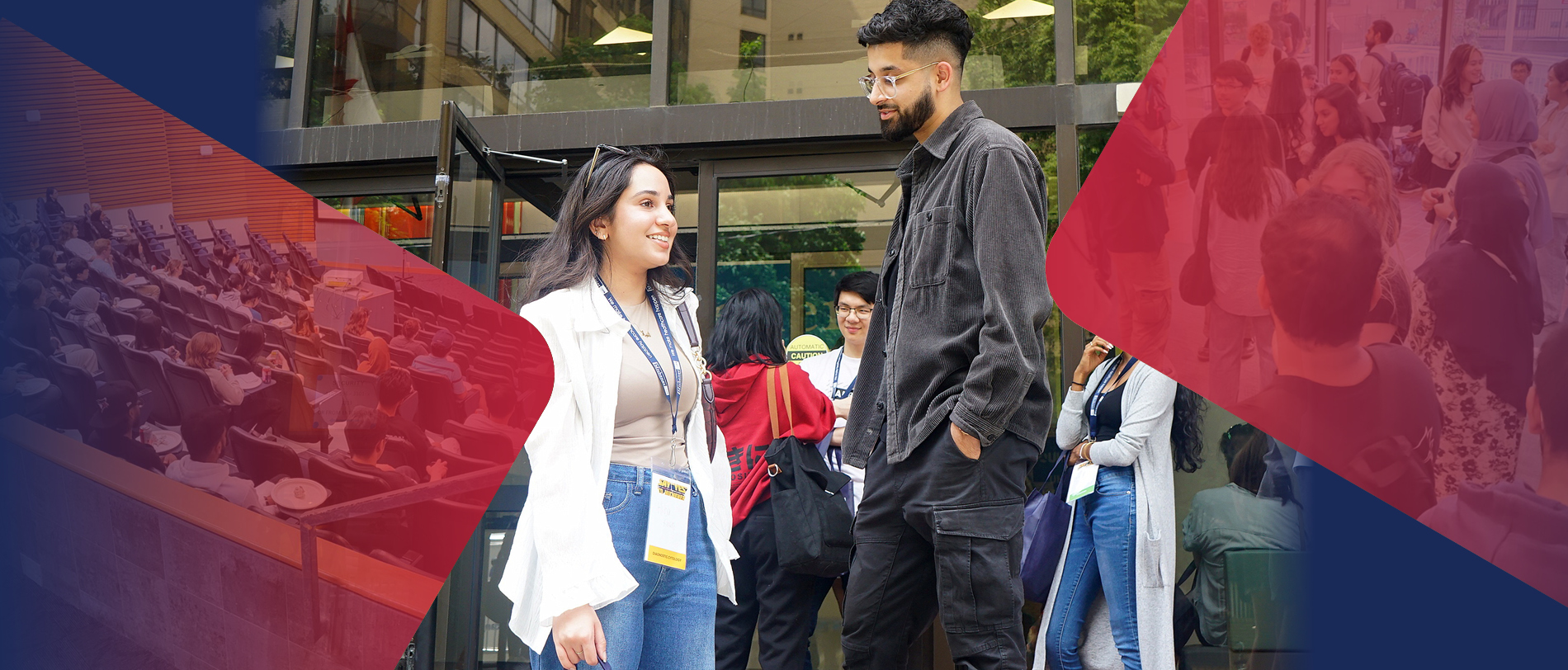 Two people stand outside a building, talking and smiling, while others gather in the background.