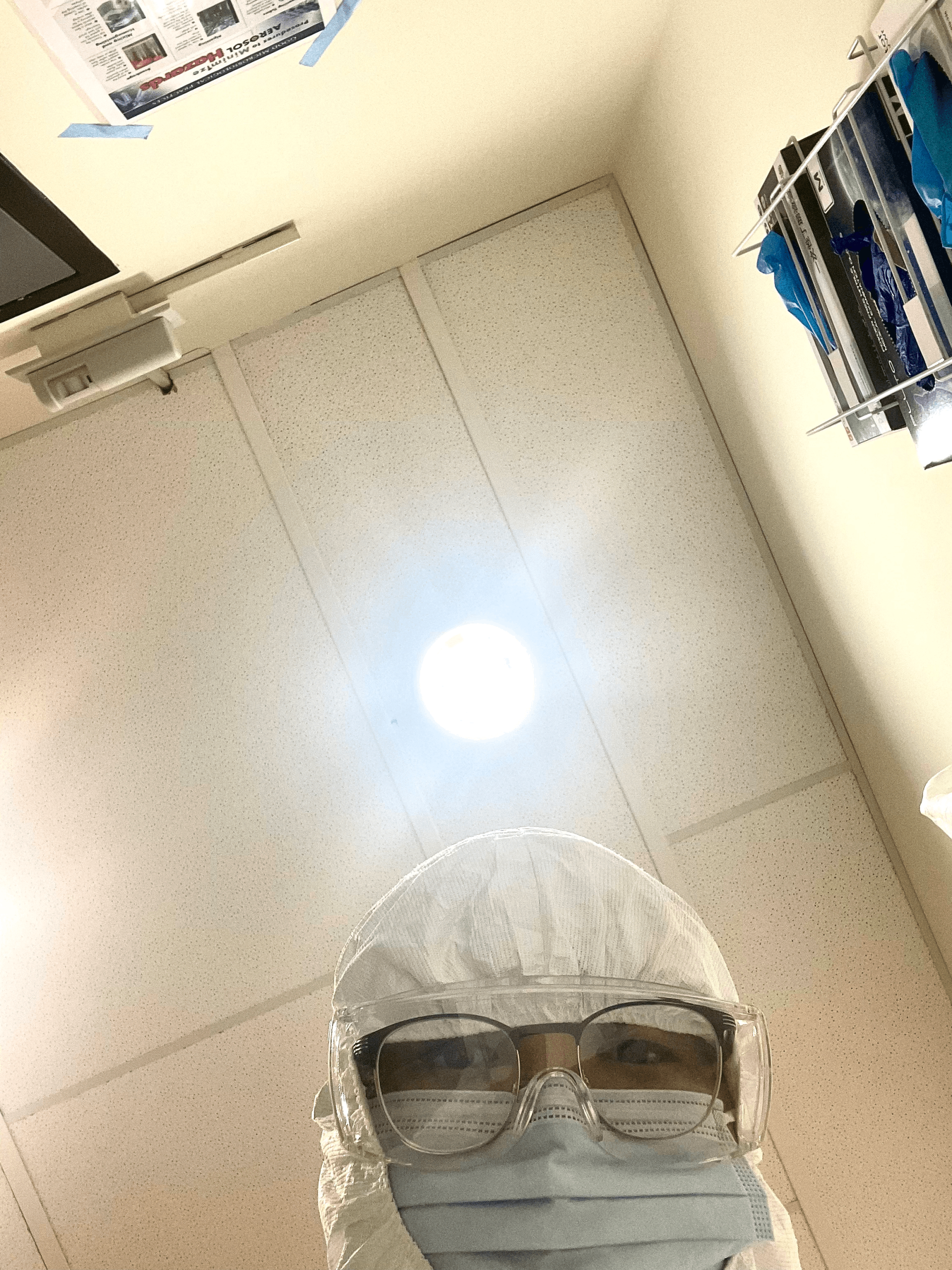 A view looking up at somewhere wearing a facemask and lab safety equipment